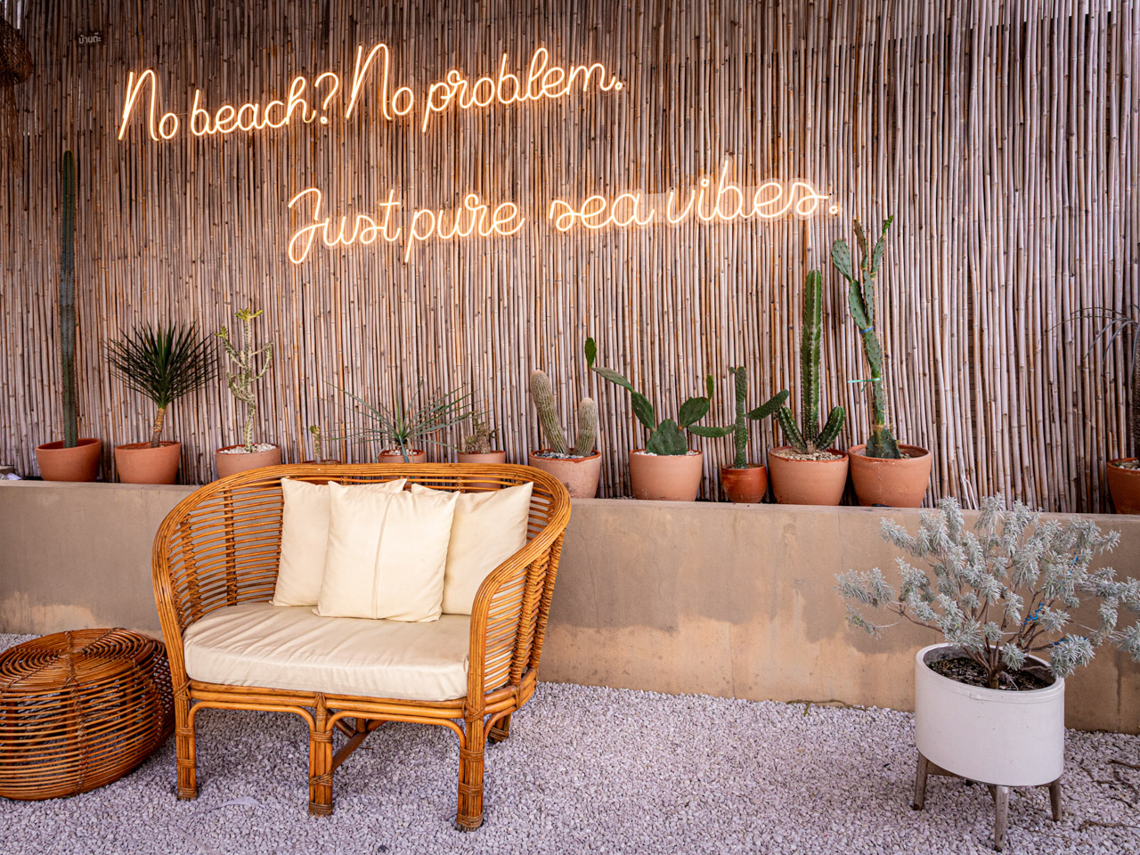 Outdoor seating area with wicker furniture and potted cacti in Bang Sare, Thailand.